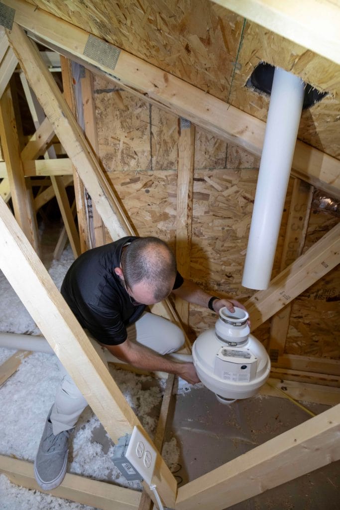 Technician Installing New Construction Mitigation System in Attic

